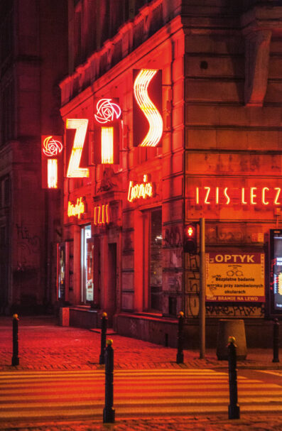 IZIS (Marszałkowska 55)
Hailing from the 70s, and with an older (uglier) brother on Pl. Bankowy, this neon flags the presence of a health and cosmetic clinic present on Warsaw’s map for over eighty-years. With its rich, red colors and enormous size, few neons in town make such a visual impact.