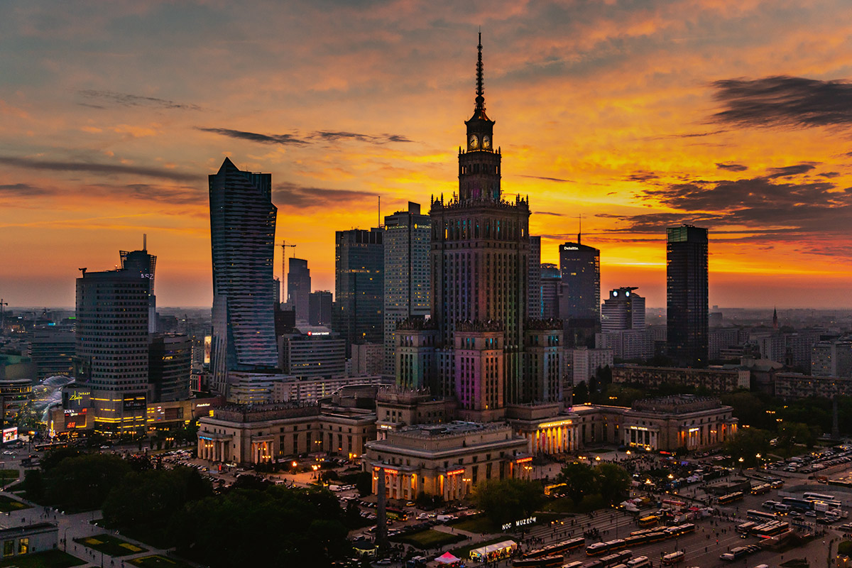 skyline view in warsaw poland palace of culture and science evening sunset orange sky skyscrapers surround